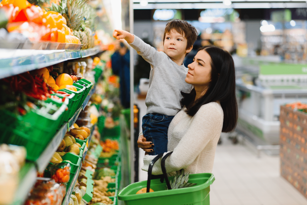 Family in the supermarket with child pointing at vegetables